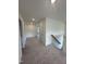 Carpeted hallway featuring multiple doorways and a staircase with handrail at 23 Quail Pt Cir, Clayton, NC 27520