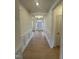 A long hallway with hardwood floors, decorative trim and a view of the front door at 23 Quail Pt Cir, Clayton, NC 27520