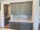 Kitchen with custom gray cabinetry, quartz countertops, and subway tile backsplash at 23 Quail Pt Cir, Clayton, NC 27520