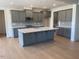 Modern kitchen with a large island, gray cabinetry, and stainless steel appliances at 23 Quail Pt Cir, Clayton, NC 27520