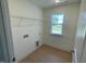 Well-lit laundry room with wooden-look flooring, wire shelving, and a window at 23 Quail Pt Cir, Clayton, NC 27520