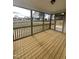 Screened porch with stained wood flooring and railing, offering a scenic outdoor living space at 23 Quail Pt Cir, Clayton, NC 27520