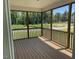 Enclosed porch featuring wood flooring, dark railings, and scenic view of trees at 23 Quail Pt Cir, Clayton, NC 27520