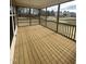 Screened porch with stained wood flooring and railing, providing a relaxing outdoor space at 23 Quail Pt Cir, Clayton, NC 27520
