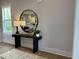 Entryway featuring a black console table with a stylish lamp and mirror reflecting an open-concept living space at 230 Grading Stick Ct, Angier, NC 27501