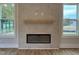 Contemporary fireplace with a tile surround, a floating mantle, and large windows on either side at 230 Grading Stick Ct, Angier, NC 27501