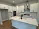 Bright kitchen featuring white cabinetry, stainless steel appliances, a large island, and modern fixtures at 230 Grading Stick Ct, Angier, NC 27501