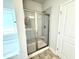 Step-in shower with glass doors, seat, and decorative tile at 328 Bishop Lane, Sanford, NC 27330