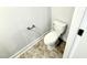 View of a standard toilet, paper holder and decorative flooring in the bathroom of this home at 328 Bishop Lane, Sanford, NC 27330