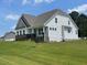 Newly constructed home with white siding, gray accents, and a lush green lawn at 52 Quail Point Cir, Clayton, NC 27520