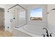 Elegant bathroom featuring a soaking tub, walk-in shower, and a window with an outdoor view at 1019 Gibson House Dr, Burlington, NC 27215