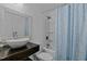 Updated bathroom features modern fixtures, vessel sink, and shower-tub combo with blue curtain at 802 N Franklin St, Wake Forest, NC 27587