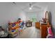 A bedroom with hardwood floors, one window, and one ceiling fan is filled with boxes at 802 N Franklin St, Wake Forest, NC 27587