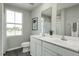 Bright bathroom showcasing a double vanity, framed mirror, and a large window at 1585 Ivy Meadow Ln, Zebulon, NC 27597