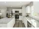 Modern kitchen with stainless steel appliances, granite countertops, white cabinets, and an island with barstool seating at 1585 Ivy Meadow Ln, Zebulon, NC 27597