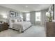 Spacious main bedroom with plush carpeting, soft lighting, and two large windows at 1585 Ivy Meadow Ln, Zebulon, NC 27597