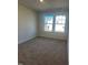 Spacious bedroom featuring two windows and neutral carpeting at 18 Clementine Street St # 207, Angier, NC 27501