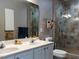 Well-lit bathroom featuring double vanity, sleek fixtures, and a tiled glass-enclosed shower at 1001 Hillsborough St # 304, Raleigh, NC 27603