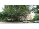 Brick apartment building featuring large shade trees, street view, and visible tenant parking at 1001 Hillsborough St # 304, Raleigh, NC 27603