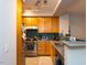 Modern kitchen with stainless steel appliances, oak cabinets, and tiled backsplash at 1001 Hillsborough St # 304, Raleigh, NC 27603