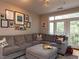 Comfortable living room with a large gray sectional, ottoman, and access to a balcony at 1001 Hillsborough St # 304, Raleigh, NC 27603
