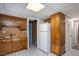Basement kitchen with classic wood cabinetry, white refrigerator, and a blue door at 3615 Octavia St, Raleigh, NC 27606