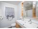 Bright bathroom featuring a double sink vanity, a large mirror, and a window at 3615 Octavia St, Raleigh, NC 27606