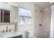 Bright bathroom featuring a marble countertop, brass fixtures, and a tiled shower with glass door at 3615 Octavia St, Raleigh, NC 27606