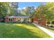 Charming red brick home features lush front lawn, walkway, and mature trees at 3615 Octavia St, Raleigh, NC 27606