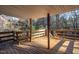 Covered porch with wooden deck, bench, and views of the surrounding trees at 3615 Octavia St, Raleigh, NC 27606