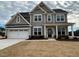 Two-story home with gray siding, white columns, and a three-car garage at 421 Ravensworth Dr, Garner, NC 27529