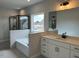 Primary bathroom featuring double sink vanity, soaking tub, and glass enclosed shower at 443 Ravensworth Dr, Garner, NC 27529
