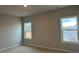 Bright bedroom featuring neutral walls, carpeted flooring, and natural light from two windows at 443 Ravensworth Dr, Garner, NC 27529