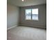 Bright bedroom featuring neutral walls, plush carpeting and a window with neighborhood views at 443 Ravensworth Dr, Garner, NC 27529