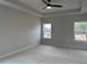 Large bedroom featuring a tray ceiling with fan, plush carpets, and two windows with neighborhood views at 443 Ravensworth Dr, Garner, NC 27529