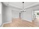 Bright dining room featuring a modern chandelier, wood floors, and neutral paint at 443 Ravensworth Dr, Garner, NC 27529