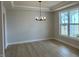 Dining room with hardwood floors, a modern chandelier, large windows, and neutral wall colors at 443 Ravensworth Dr, Garner, NC 27529