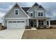 Charming two-story home with gray siding, white trim, a two-car garage, and a well-manicured lawn at 443 Ravensworth Dr, Garner, NC 27529