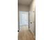 Hallway featuring hardwood floors, neutral wall colors, and white doors with black hardware at 443 Ravensworth Dr, Garner, NC 27529