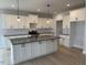 Modern kitchen featuring an island, white cabinets, stainless steel appliances, and subway tile backsplash at 443 Ravensworth Dr, Garner, NC 27529