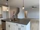 Open-concept kitchen island with seating, stainless steel appliances, and an adjacent living area at 443 Ravensworth Dr, Garner, NC 27529