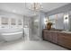 The bathroom features a modern tub, glass shower, double vanity, unique chandelier, and large windows at 3723 Bellevue Rd, Raleigh, NC 27609