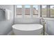 This modern bathtub is lined by large windows with a sleek gold faucet to create a spa-like retreat at 3723 Bellevue Rd, Raleigh, NC 27609