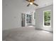 A bright bedroom with a large window, storage shelves, ceiling fan, and neutral walls at 3723 Bellevue Rd, Raleigh, NC 27609