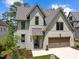 Two-story home with gray brick exterior, two-car garage, and landscaped yard at 3723 Bellevue Rd, Raleigh, NC 27609