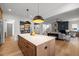 Open-concept kitchen featuring a center island with quartz countertops, stainless steel appliances, and hardwood floors at 3723 Bellevue Rd, Raleigh, NC 27609