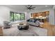 Bright open-concept living room with hardwood floors, a ceiling fan, and backyard views at 3723 Bellevue Rd, Raleigh, NC 27609