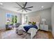 This main bedroom features two plush sitting chairs, soft decor, a ceiling fan, and lots of natural light at 3723 Bellevue Rd, Raleigh, NC 27609