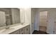 Well-lit bathroom with double vanity, modern fixtures, and walk-in closet access at 141 Robert Howe Dr, Fuquay Varina, NC 27526