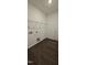Functional laundry room featuring dark vinyl floors and shelving for efficient storage at 141 Robert Howe Dr, Fuquay Varina, NC 27526